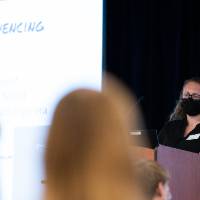 Mentor wearing mask introducing scholar.